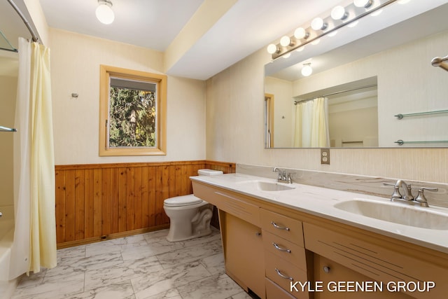 full bathroom with toilet, vanity, wood walls, and shower / tub combo with curtain