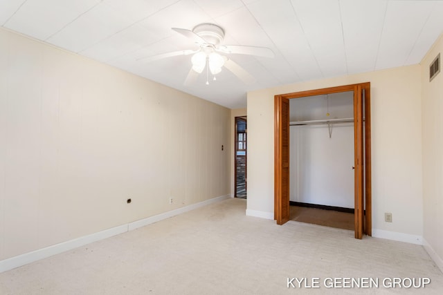 unfurnished bedroom featuring ceiling fan, light colored carpet, and a closet