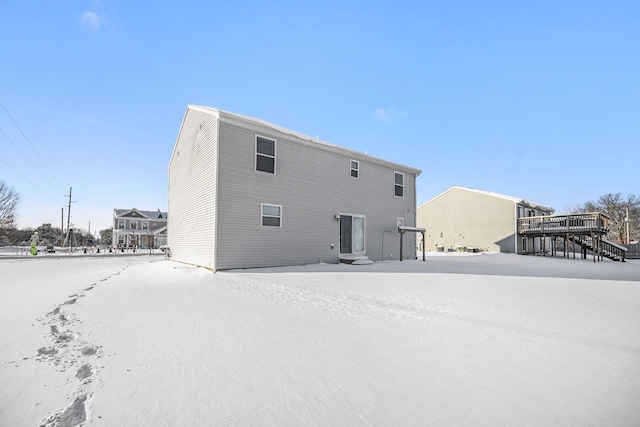 view of snow covered back of property