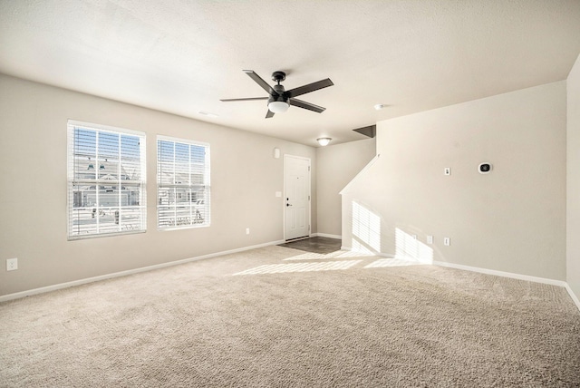 unfurnished living room featuring ceiling fan and light colored carpet