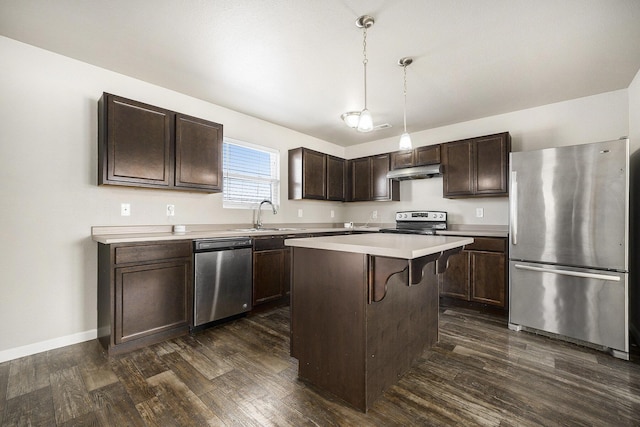 kitchen with hanging light fixtures, dark hardwood / wood-style flooring, appliances with stainless steel finishes, a kitchen island, and dark brown cabinetry