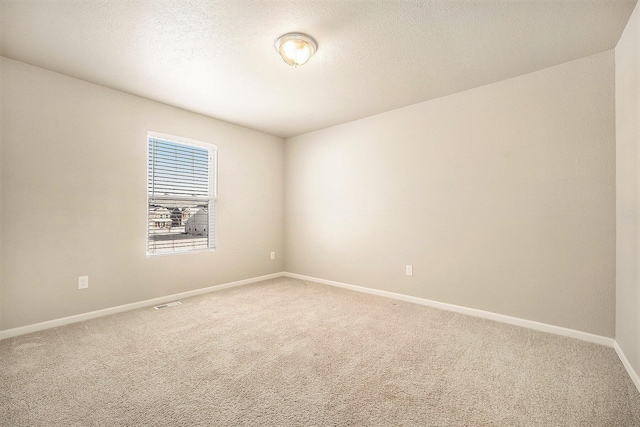 spare room featuring a textured ceiling and carpet floors