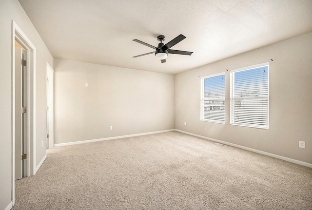 spare room featuring light carpet and ceiling fan