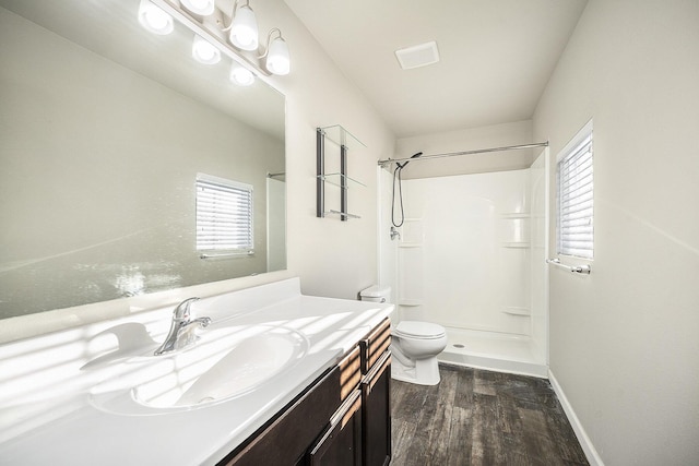 bathroom featuring hardwood / wood-style flooring, toilet, a healthy amount of sunlight, and vanity