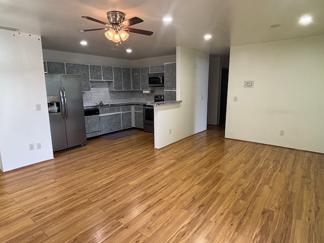 kitchen with stainless steel appliances, light hardwood / wood-style flooring, ceiling fan, and decorative backsplash