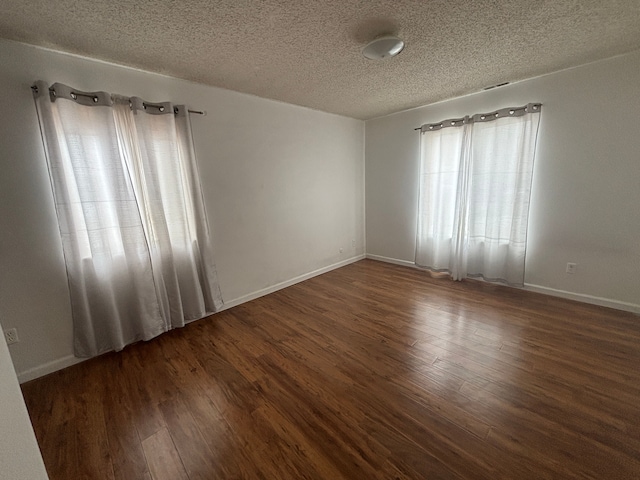 unfurnished room with dark hardwood / wood-style floors and a textured ceiling