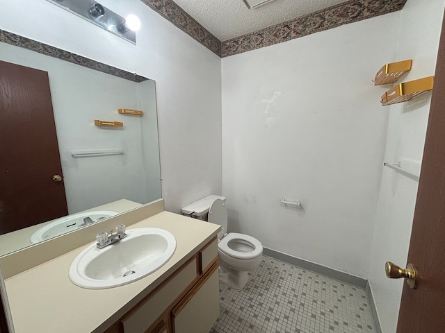 bathroom with vanity, a textured ceiling, and toilet