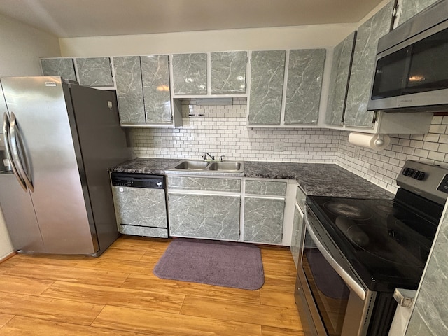 kitchen featuring sink, backsplash, stainless steel appliances, and light hardwood / wood-style floors