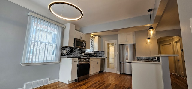 kitchen featuring white cabinets, decorative light fixtures, dark wood-type flooring, stainless steel appliances, and tasteful backsplash