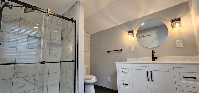 bathroom featuring vaulted ceiling, toilet, a shower with shower door, and vanity