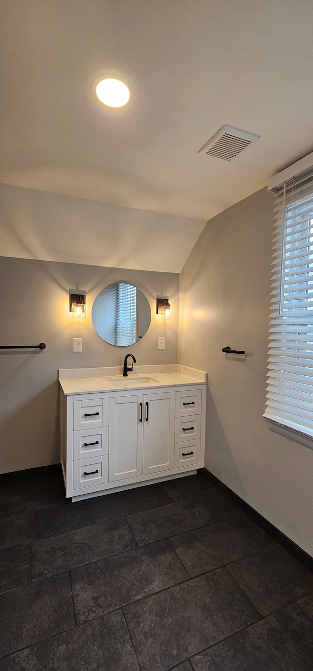 bathroom featuring vanity and lofted ceiling