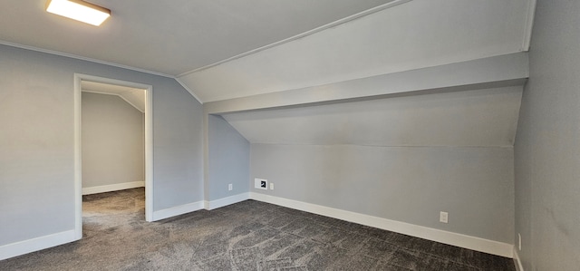 additional living space with vaulted ceiling and dark colored carpet