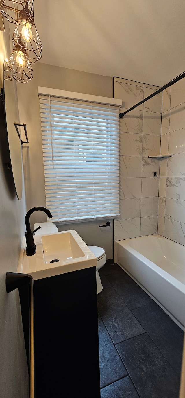 full bathroom featuring vanity, toilet, tile patterned floors, and tiled shower / bath combo