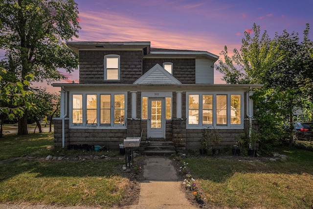 view of front of home with a lawn and a sunroom