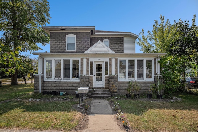 view of front of house with a sunroom and a front yard