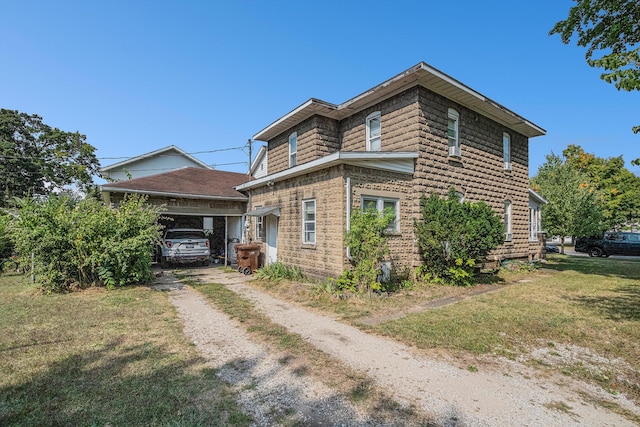 view of side of home with a yard and a carport