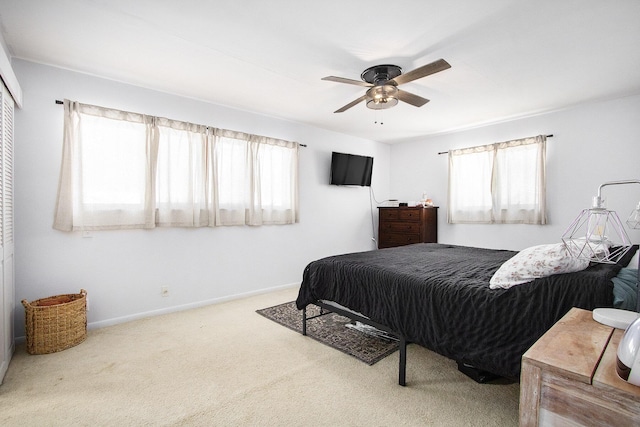 carpeted bedroom featuring ceiling fan and multiple windows