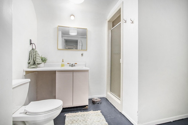 bathroom featuring toilet, a shower with shower door, and vanity