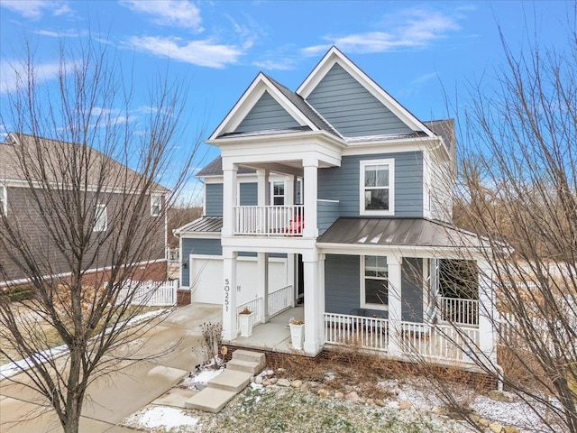 view of front facade with a garage, a balcony, and a porch