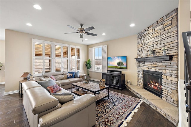 living room with dark hardwood / wood-style floors, ceiling fan, and a fireplace