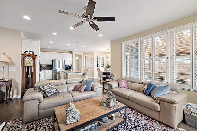 living room with ceiling fan, sink, dark hardwood / wood-style floors, and a healthy amount of sunlight