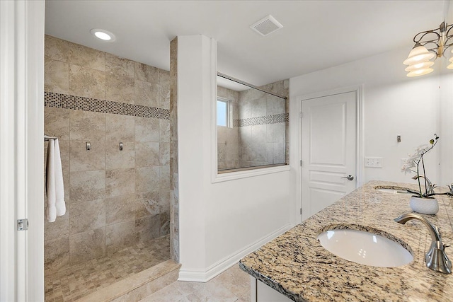 bathroom with vanity, a tile shower, and tile patterned floors