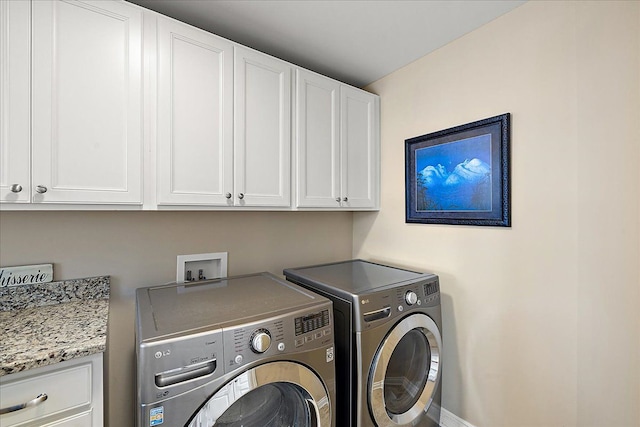 washroom featuring separate washer and dryer and cabinets