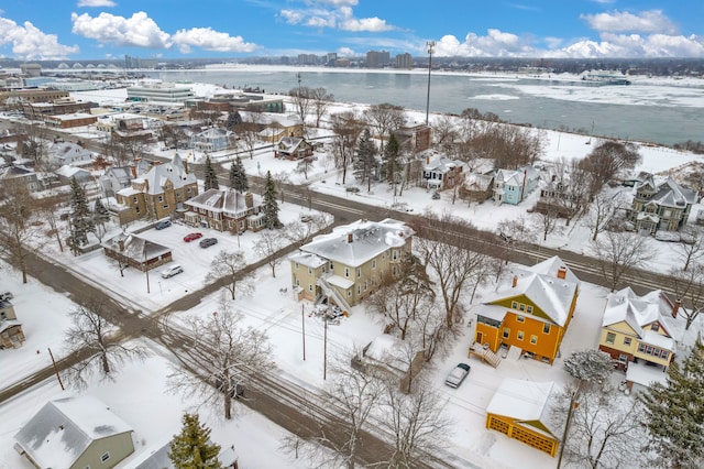 snowy aerial view featuring a water view