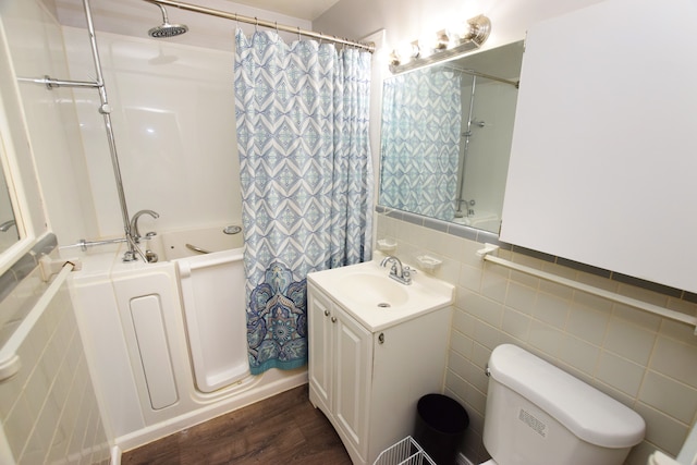 full bathroom featuring wood-type flooring, tile walls, toilet, shower / bath combination with curtain, and vanity