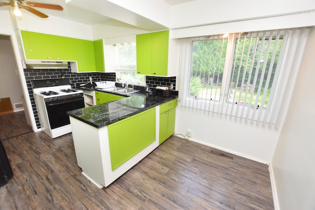 kitchen featuring decorative backsplash, sink, dark hardwood / wood-style floors, kitchen peninsula, and gas range