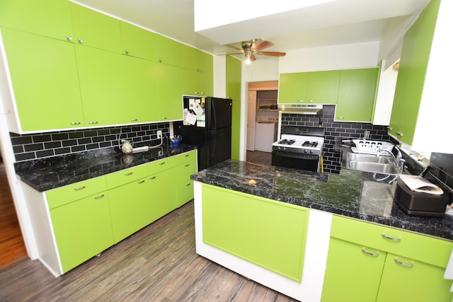 kitchen featuring black refrigerator, white range with gas stovetop, sink, backsplash, and green cabinetry