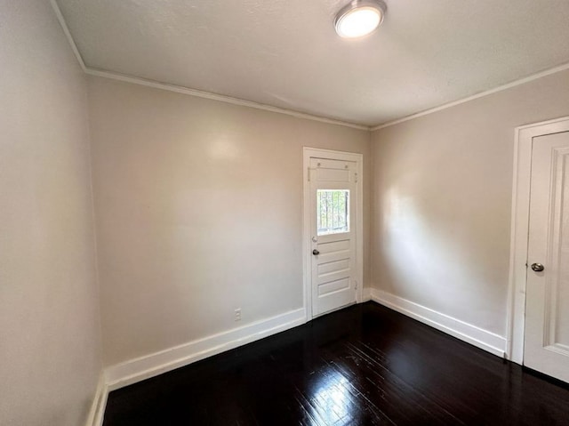 empty room featuring crown molding and dark hardwood / wood-style floors