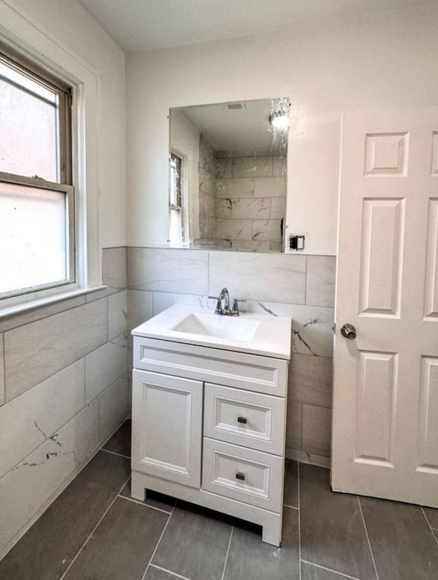 bathroom featuring tile walls, tile patterned floors, and vanity