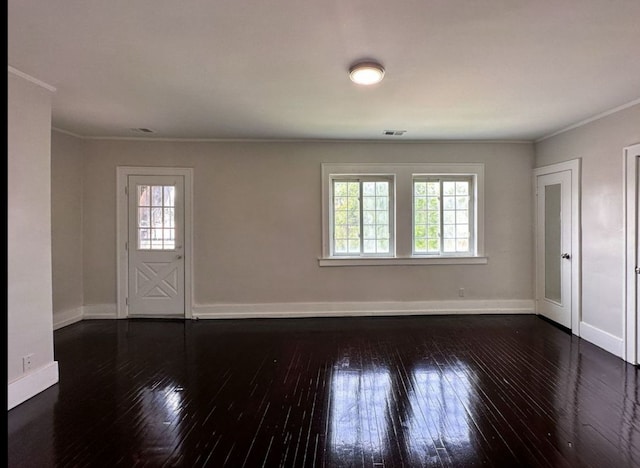 empty room with crown molding and dark hardwood / wood-style floors