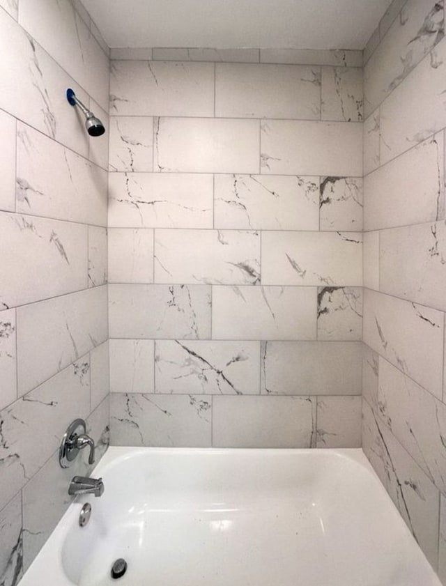 bathroom featuring tiled shower / bath