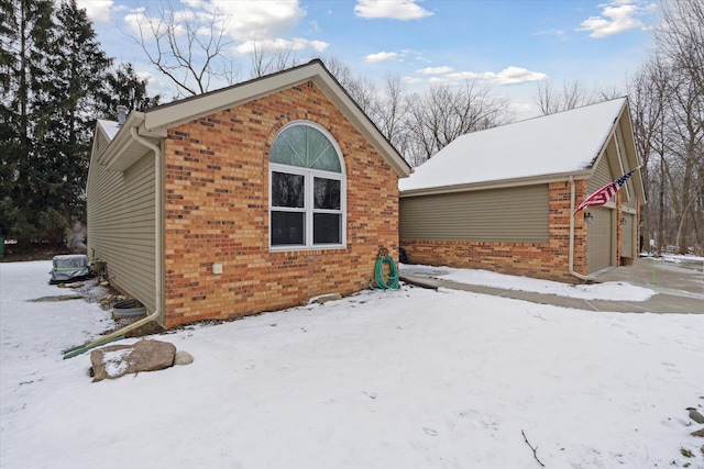 snow covered property with a garage