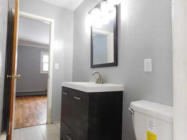 bathroom with a baseboard radiator, vanity, toilet, and tile patterned floors