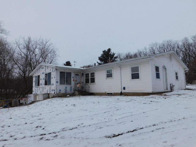 view of snow covered back of property