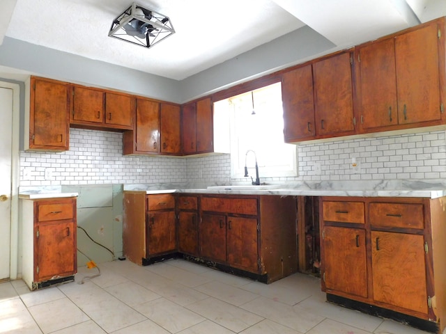 kitchen featuring sink, decorative backsplash, and light tile patterned floors