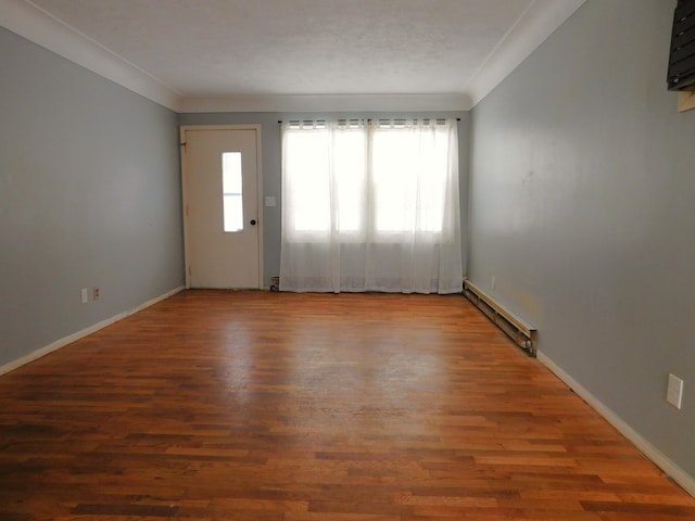 spare room with crown molding, hardwood / wood-style flooring, and a baseboard radiator