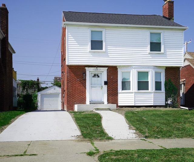 view of front of home with a front yard, an outbuilding, and a garage