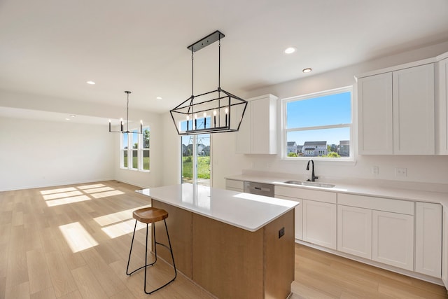 11964 Timber Ct, Bruce, MI 48065 - kitchen with a center island, a sink, light countertops, light wood finished floors, and a notable chandelier