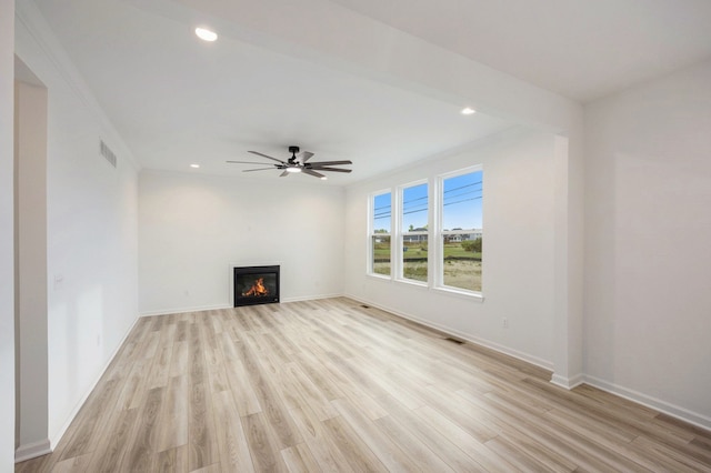 11964 Timber Ct, Bruce, MI 48065 - unfurnished living room featuring visible vents, a glass covered fireplace, baseboards, a ceiling fan, and light wood-style flooring