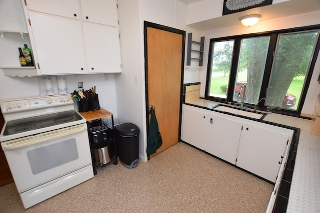 kitchen with sink, white electric range oven, and white cabinets