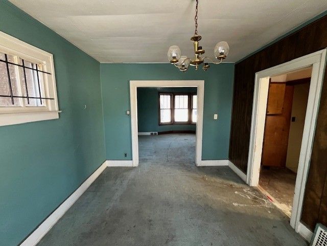 unfurnished dining area with a chandelier