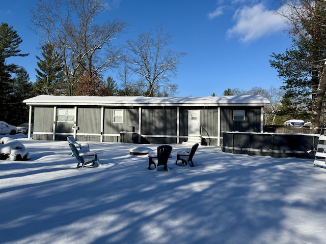 view of snow covered back of property