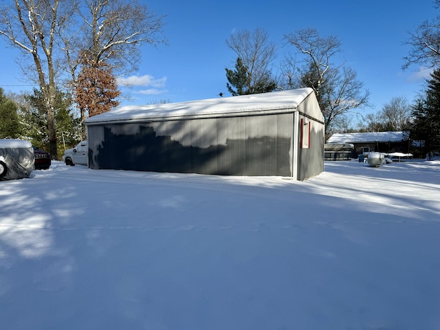 view of snowy exterior with an outbuilding