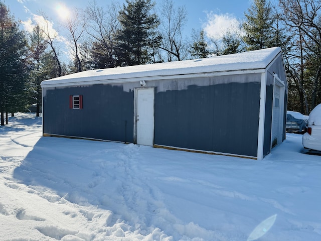 snow covered structure with a garage