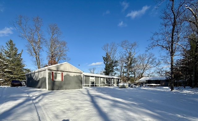 view of snow covered exterior featuring a sunroom