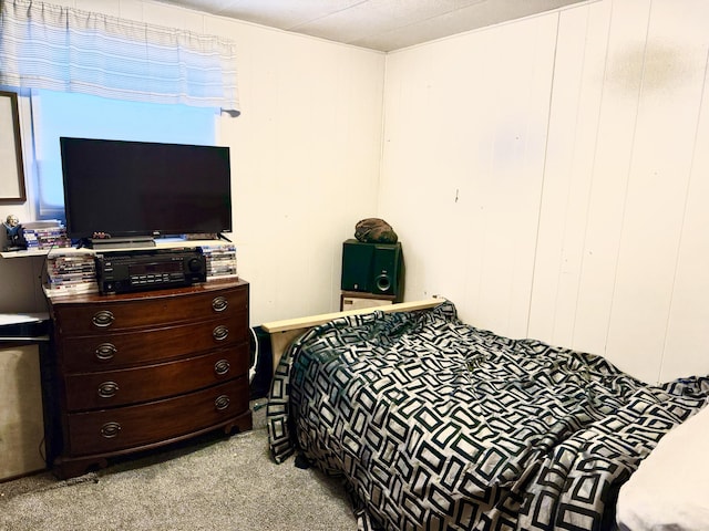 bedroom featuring wood walls and light colored carpet